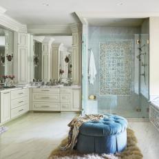 Elegant Main Bathroom With Blue Ottoman, Shower With Glass Door and Double Vanity 