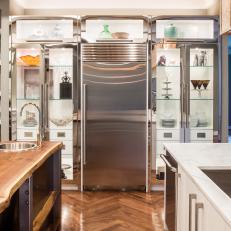 Glamorous Back Lit, Glass Door Cabinets Surrounding Stainless Steel Refrigerator in Contemporary Kitchen 