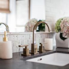 Brass Bathroom Sink Hardware and Black Countertop