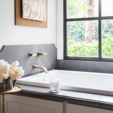 Soaking Tub With Gray Marble and Flowers