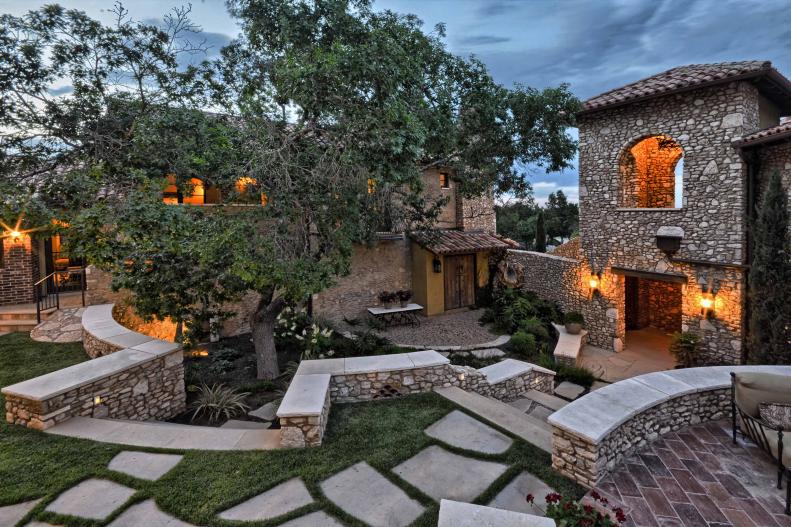 Mediterranean Exterior With Stone Siding, Walkways and Retaining Walls