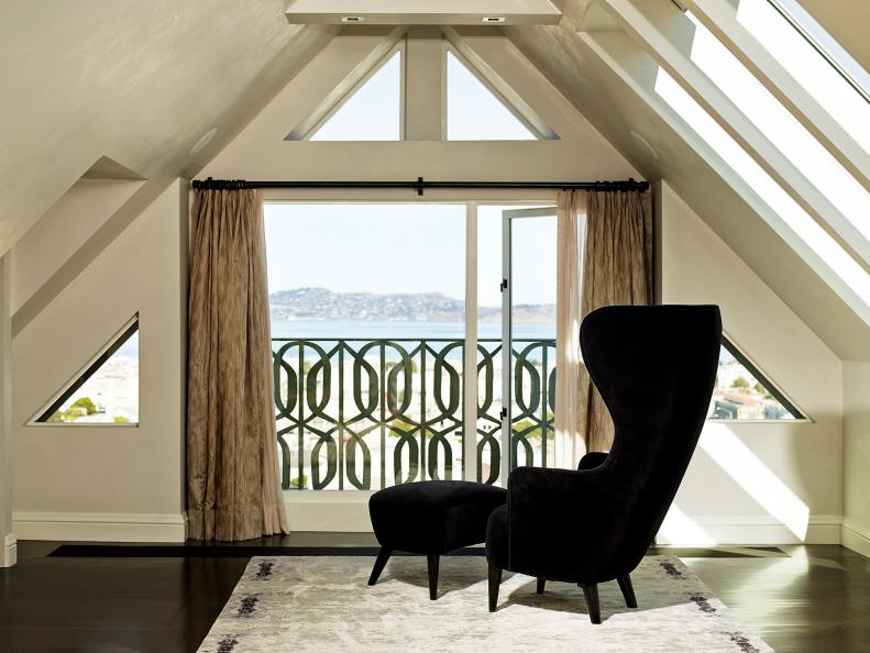 Modern Living Room With Black Armchair, Ottoman & Ocean View