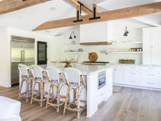Spacious, Open Design Kitchen With Eat-In Island, White Cabinets Over White Brick Wall and Exposed Wood Beams