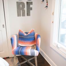 Southwestern Blue and Orange Pattern Chair Over Hardwood Floor and Under Surf Letter Wall Decor 