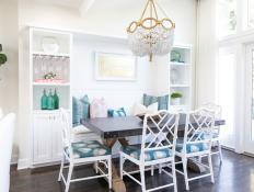 Sunny Coastal Dining Room With Bench Seating Surrounded by Shelf Frame, Dark Wood Dining Table and Blue Accents 