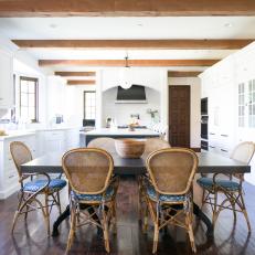 Open Design Dining Room And Kitchen With Dark Table, Coastal Chairs With Blue Seat Cushions and Exposed Wood Beams