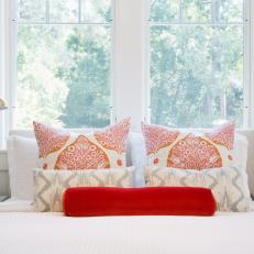 White Bed With Orange and Red Pillows