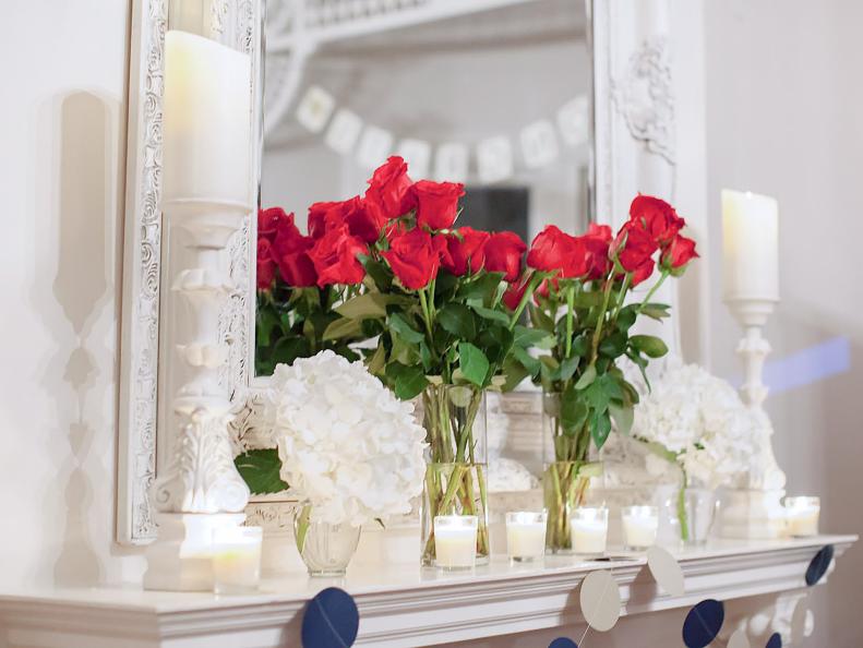 White Mantel With Red Roses and Glass Votive Candles