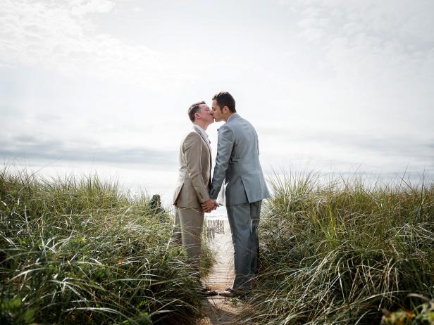 Two Men Holding Hands and Kissing at the Beach