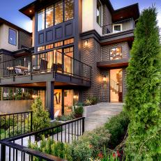 Urban Home Exterior With Mixed Material Finishes, Iron Railing Lined Balconies and Uncovered Windows 