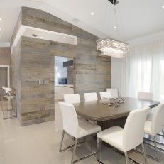 Modern Dining Room With Vaulted Ceiling and Neutral Tile Walls