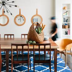 Contemporary Dining Room With Sleek Wood Dining Table, Orange End Chair and Blue Pattern Rug 