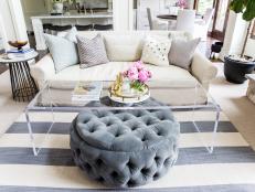 Living Room Space with White Sofa, Clear Acrylic Table and Grey Pouf Ottoman