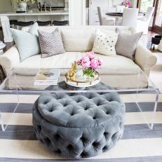 Grey Pouf Ottoman, End Table and Pops of Color Accent the Space