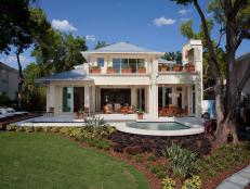 Back View of French Indies Inspired Home with Pool and Decks