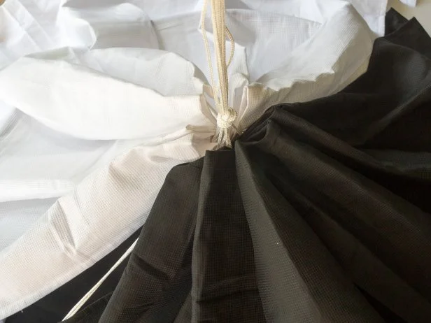Tie an overhand knot at the base of the gathered shower curtain. Spread the curtain around the hula hoop frame to create the tent.