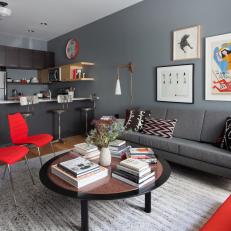 Connected Midcentury Modern Living Room and Kitchen With Gray Walls and Bright Red Accents