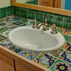 Decorative Southwester Tile Countertop Surrounding White Sink With Stainless Steel Faucet and Water Knobs 
