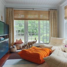 Neutral Transitional Media Room With Orange Ottoman