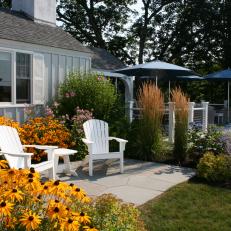 Small Patio With White Adirondack Chairs