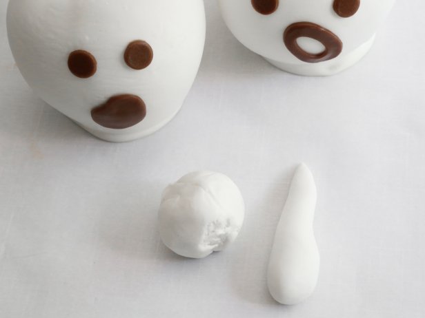 Use white ready-made fondant to create cone shapes and thread them onto the apple sticks.