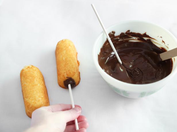 Dip the ends of the pop sticks into chocolate and then insert them into each snack cake. Transfer to the refrigerator and chill until set, about 5 minutes.