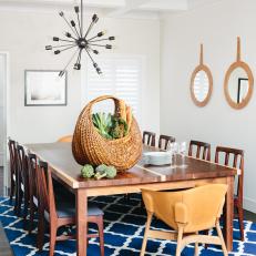 Bright Dining Room With Blue Patterned Rug, Large Dining Table and Modern Stainless Steel Light Fixture 