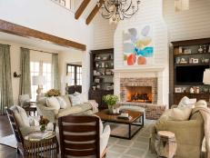 Open, Tall Ceiling With Wood Beams, Shiplap Accent Wall Over the Fireplace and Soft Green Sofas 