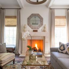 Traditional Sitting Room With Gold Framed Coffee Table, Thick Neutral Mantel and Floral Neutral Area Rug 