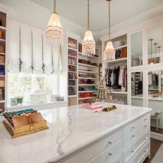 Marble Countertop Island and Beaded Pendant Lights In Massive Walk In Women's Closet With Open Shelving