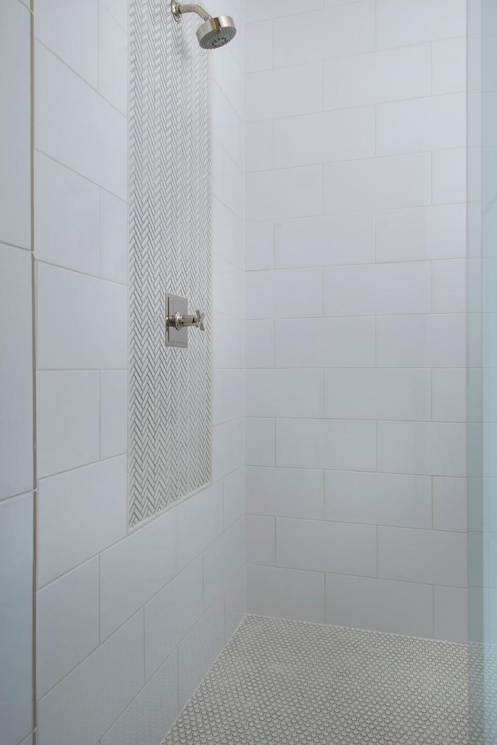 White Shower Featuring a Tile Accent Panel Framing the Shower Head and a Penny Tile Floor HGTV
