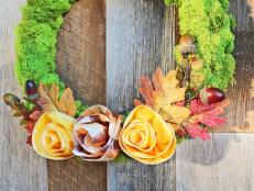 Craft a cheery touch of fall for your front door with a moss-covered wreath form and autumnal ribbon roses. 