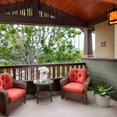 Cozy Covered Balcony With Rich Wood Ceiling, Red Cushioned Wicker Chairs and Warm Glow Lantern Light 