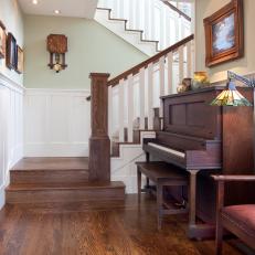 Craftsman Foyer With Wood Staircase Passing a Rich Wood Piano With Stained Glass Lamp