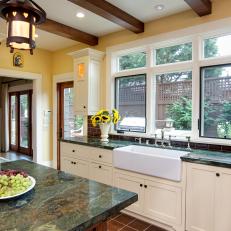Forest Green Marble Countertop, Large White Farmhouse Sink and Exposed Wood Beams in Craftsman Kitchen 