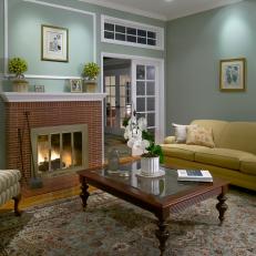 Sea Green Living Room With Yellow Sofa, Striped Armchair and Brick Fireplace Surround 