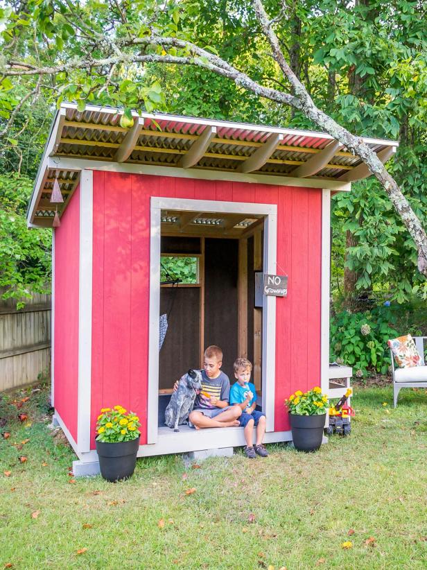 Red Shed Playhouse with Kids and Dogs Sitting in it
