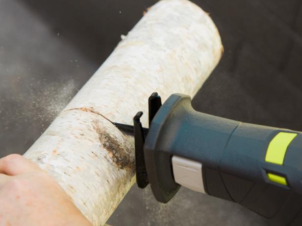 Determine the height of your vase and mark it on the log. Using a reciprocating saw, cut the log to size. Have someone hold the log in place as you cut to get a nice straight cut.