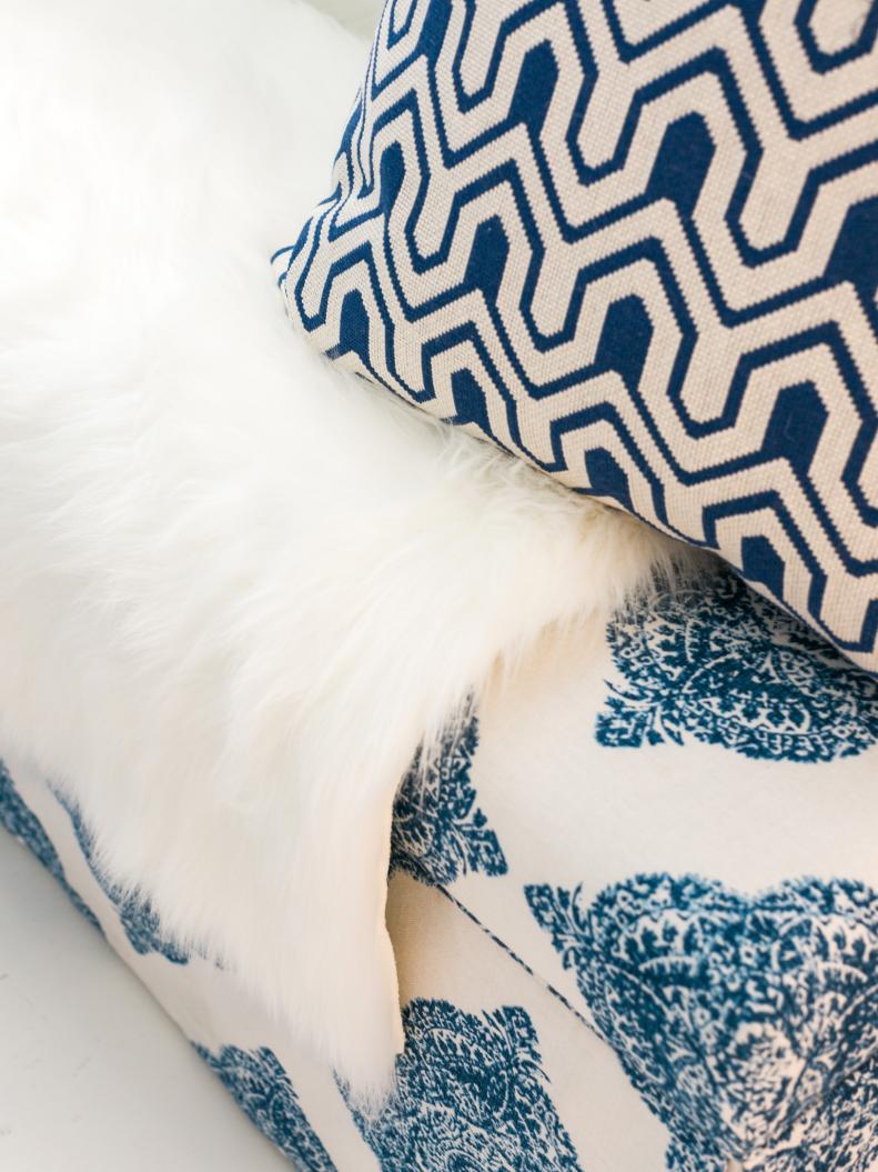 Blue-and-White Pillow Atop Faux-Fur Throw