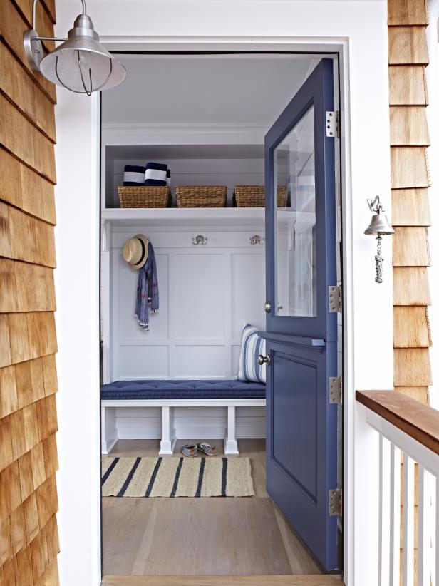 White Coastal Mudroom With Navy Blue Door & Cushioned Bench