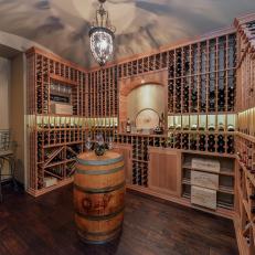 Wine Cellar With Built in Wood Wine Racks, Barrel Tasting Table and Elegant Light Fixture 