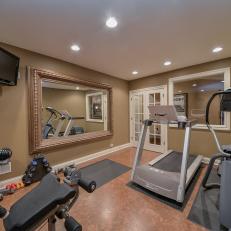 Home Gym With Large, Traditional, Thick Frame Mirror, Mounted Flatscreen TV and Exercise Machines Under Recessed Lighting