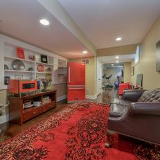 Midcentury Modern Living Space With Tufted Leather Sofa, Vibrant Red Patterned Rug and Red Appliances 