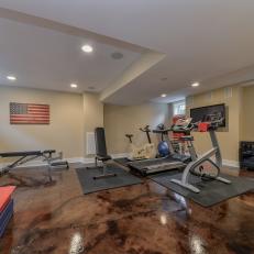 Basement Home Gym With Brown Stone Flooring, Tray Ceiling With Recessed Lighting and Neutral Walls 