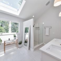 Spacious White Bathroom With Skylight, Full Length Framed Mirror and Potted Plants for Natural Color 