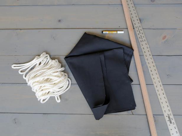 Supplies:
-1 1/4" x 3' oak dowel 
-3/8" x 16' braided polypropylene rope
-2 yards of black canvas 
-White fabric paint pen

Tools:
-drill and 3/8" drill bit
-sewing machine
-iron 
-shears
-yardstick
-lighter