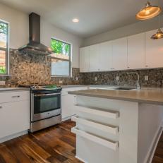 Bright, Modern Kitchen With Natural Stone Backsplash, Stainless Steel Range Hood and Sleek White Cabinets 