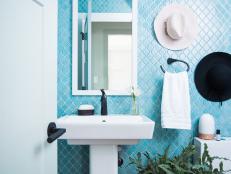 In the laundry, a more traditional graphic pattern recalling antique ironwork covers the walls, while in the powder room, pretty quatrefoil tiles in a fitting powder blue give a romantic air. 