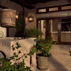 Italian Villa Courtyard With Wrought Iron Bucket Support Over Decorative Well, Wood French Doors and Lantern Sconces