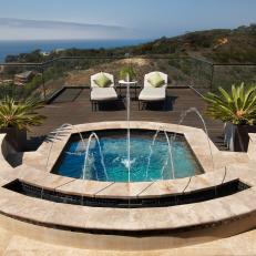 Luxurious Hot Tub With Waterfall Features, Potted Palms, Neutral Cushioned Lounge Chairs and Ocean View